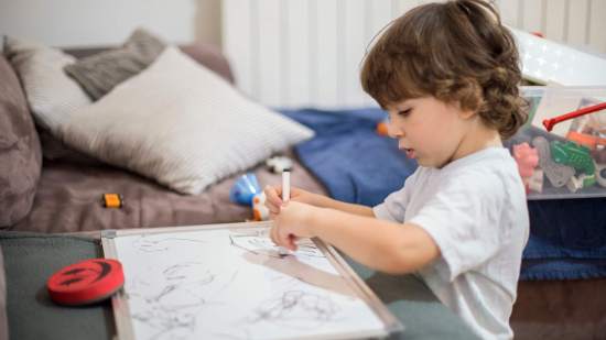 Un niño se concentra dibujando