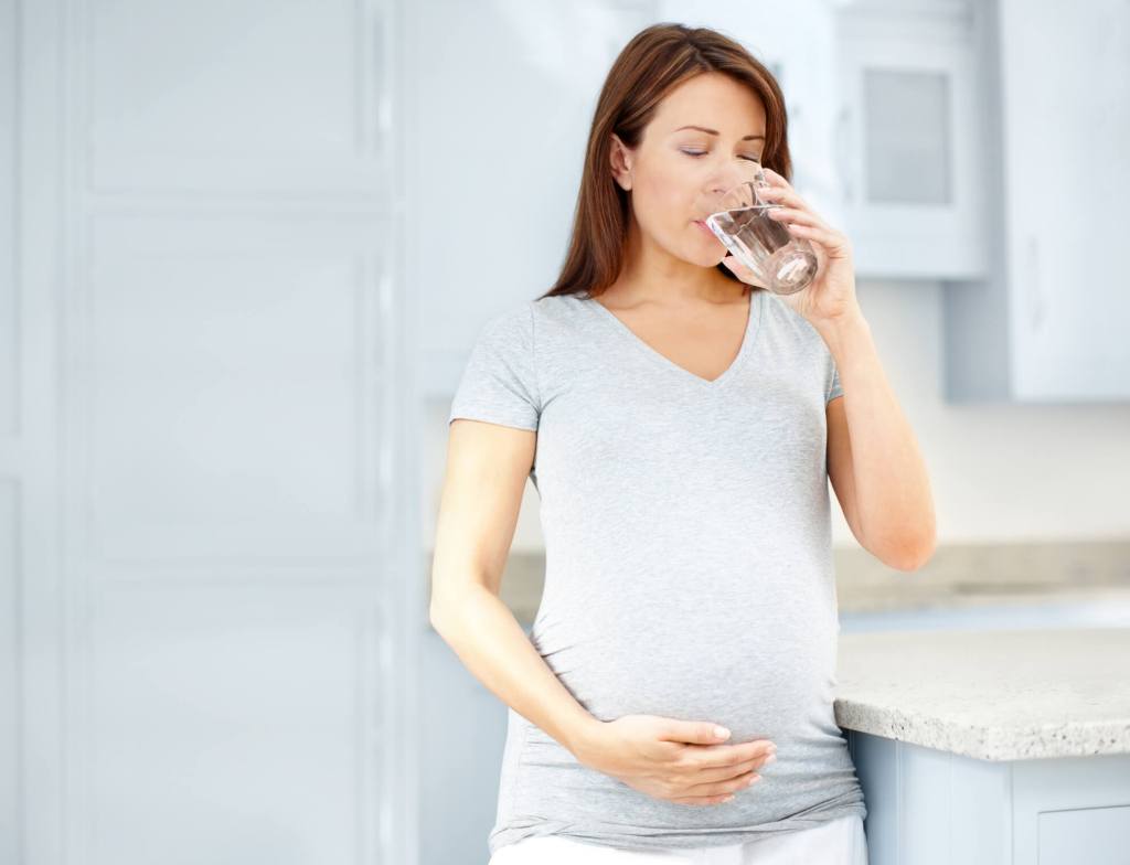 Mujer embarazada bebiendo agua