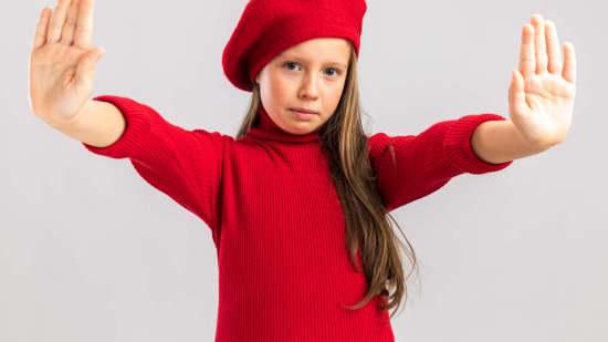 serious-little-blonde-girl-wearing-red-beret-showing-stop-gesture-looking-front-isolated-white-wall