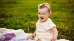 plump-little-girl-sits-white-blanket