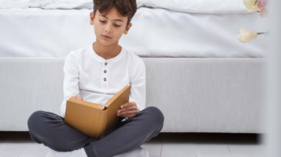 front-view-young-boy-home-reading
