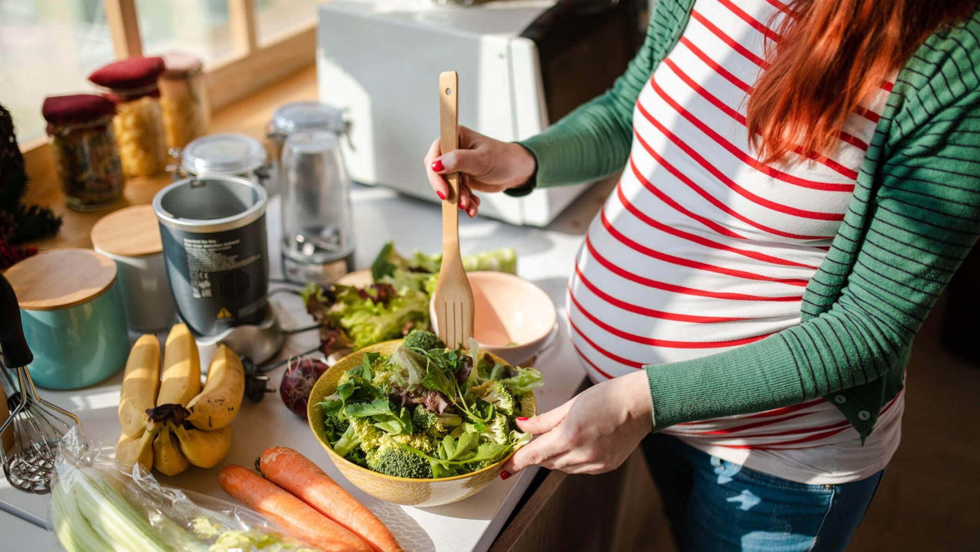 Una mujer embarazada se hace una ensalada