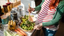 Una mujer embarazada se hace una ensalada