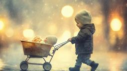 Un niño pasea un bebé de juguete