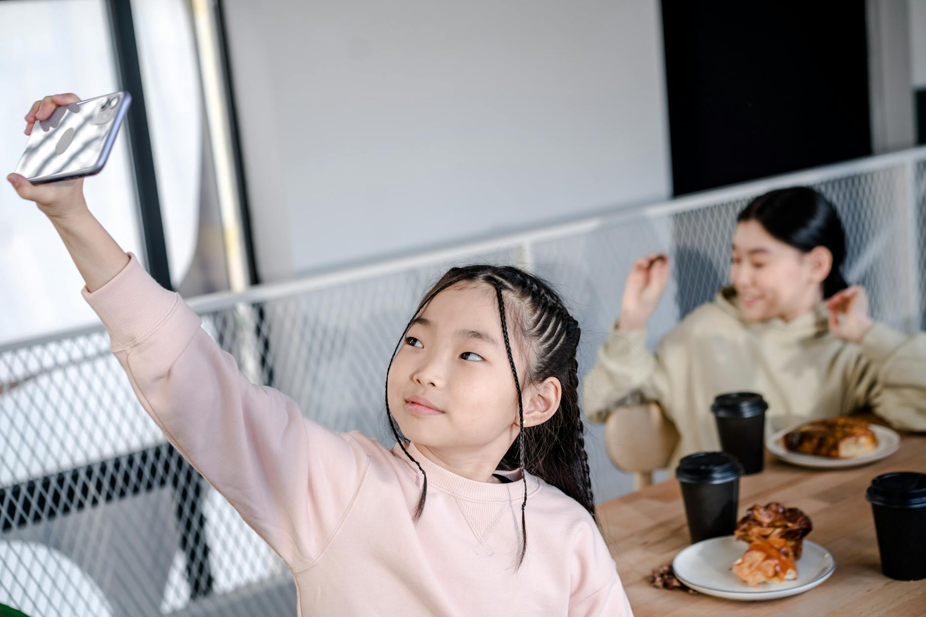 shallow focus of a girl taking picture of herself using her mobile phone