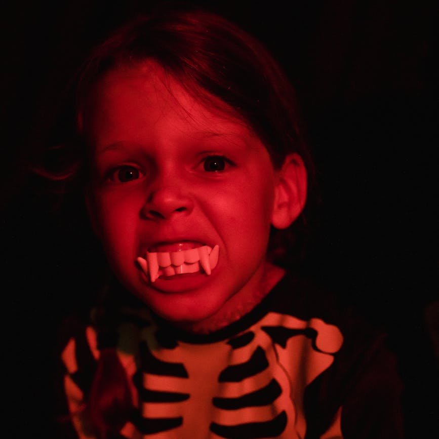 portrait of girl with artificial teeth wearing skeleton costume
