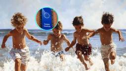 Niños jugando en la playa. En pequeño, la sede de la Comisión Europea
