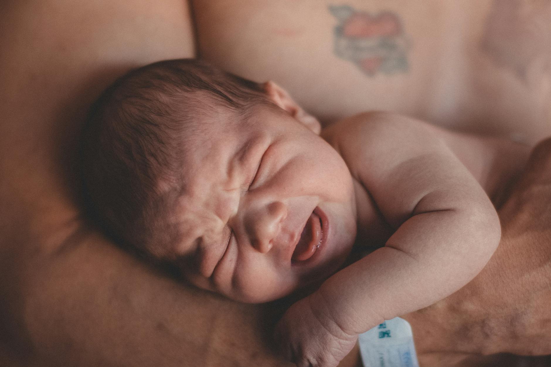 topless man carrying a baby