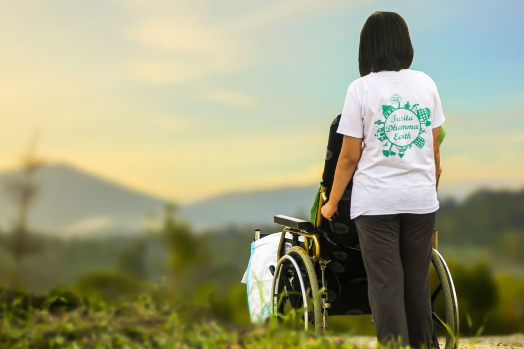Cuidadora empujando una silla de ruedas