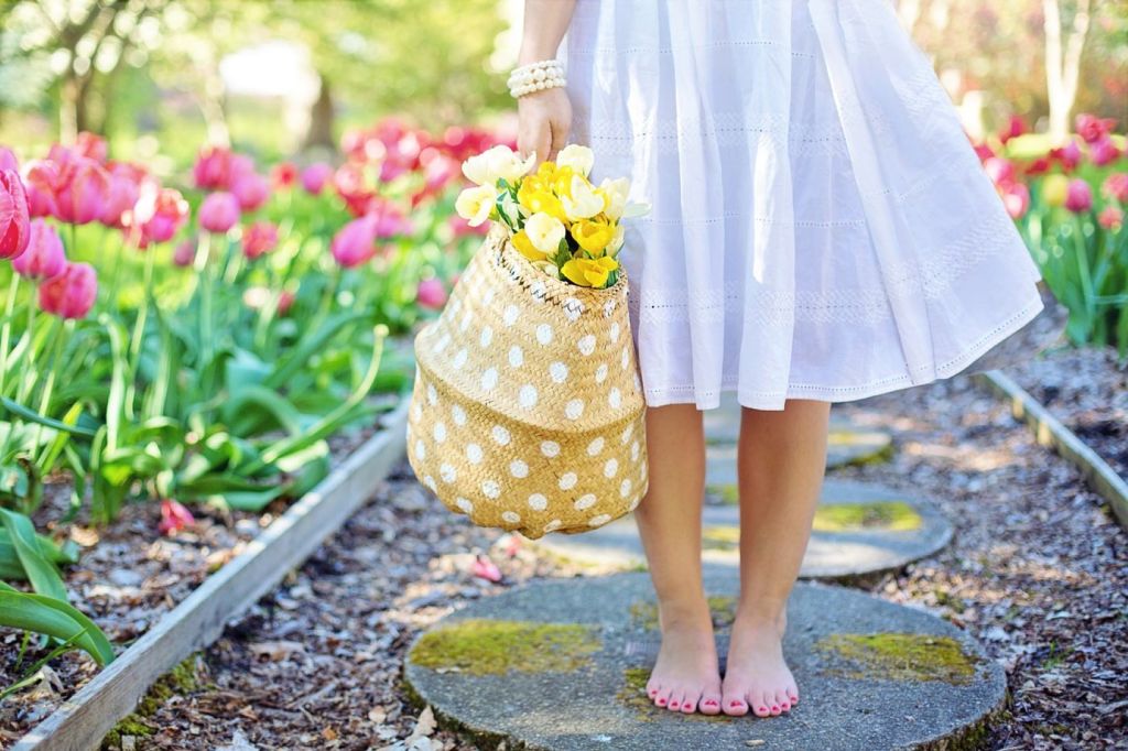 Mujer con vestido blanco y cesta de flores