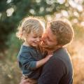 Un padre ríe con su hijo al atardecer. Las primeras experiencias compartidas dejan huella en la infancia.