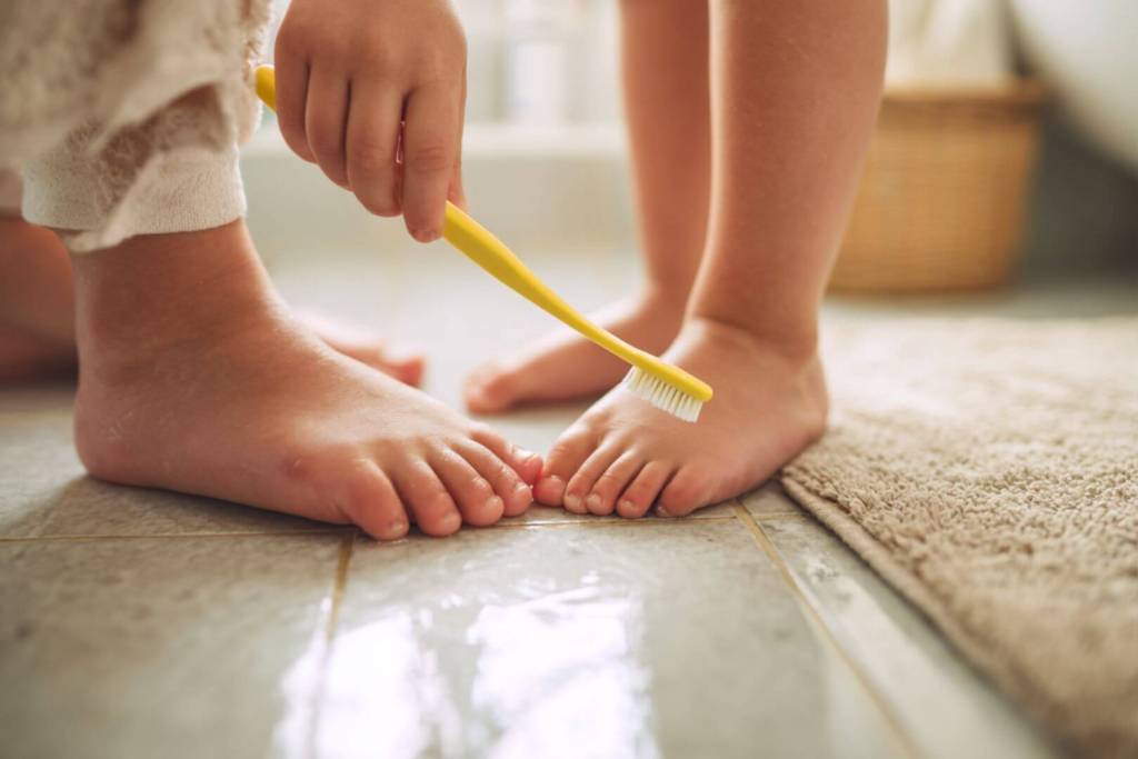 El truco más sencillo: un adulto limpia las uñas de los pies de un niño con un cepillo suave y mucho cuidado.