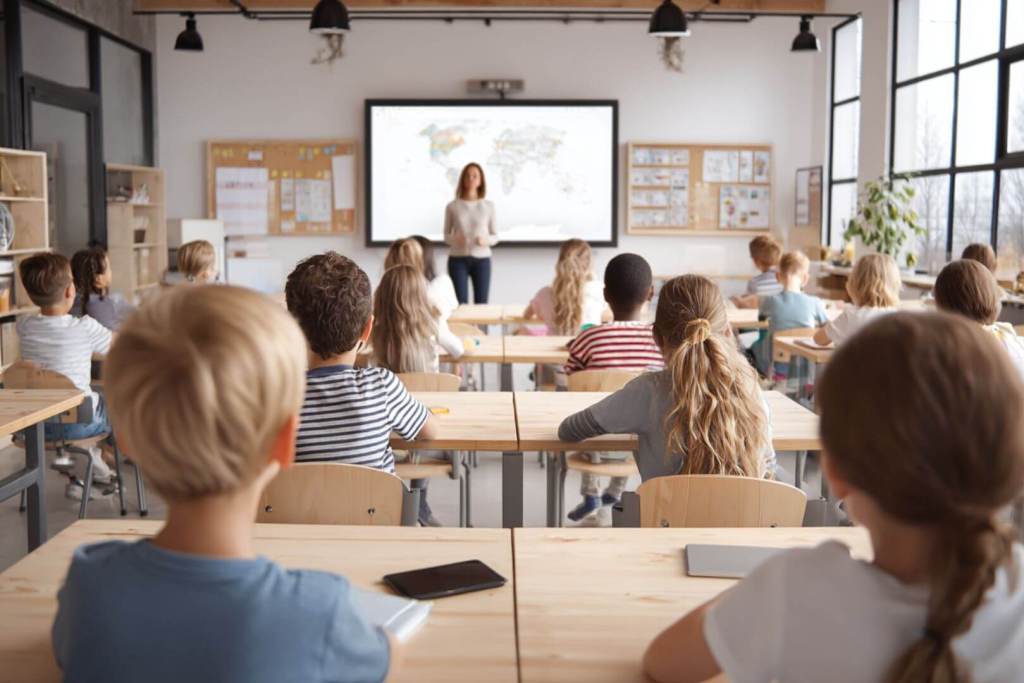 Estudiantes concentrados en clase con distracciones tecnológicas.