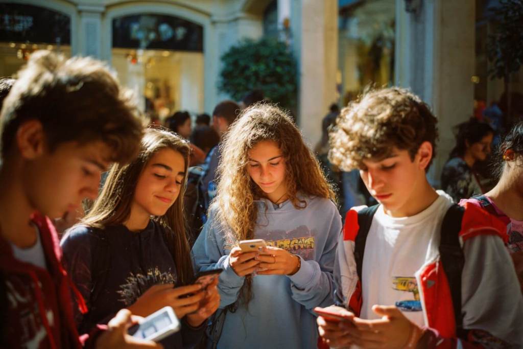 Adolescentes pendientes de sus smartphones en una calle céntrica.