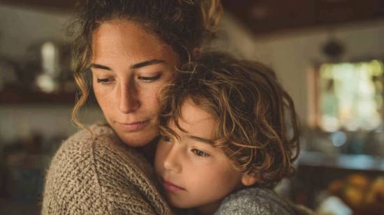 Una madre abraza a su hijo mientras afrontan juntos los retos de los trastornos alimentarios en la infancia