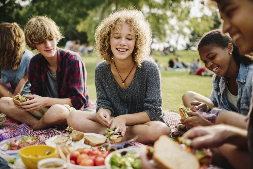 Un grupo de adolescentes disfrutando de una mesa repleta de comida saludable