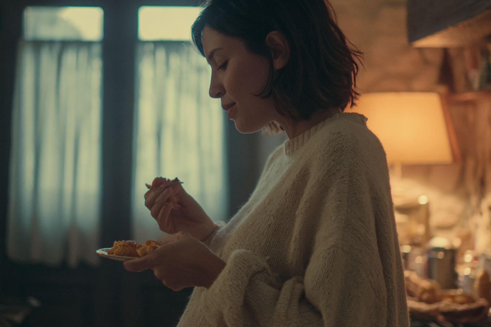 Mujer embarazada comiendo pasta en casa