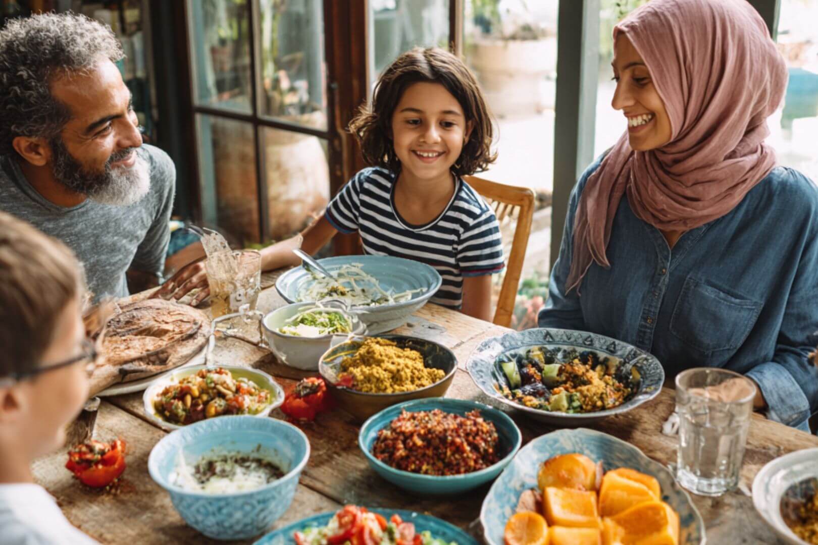 Familia reunida en la mesa disfrutando de un almuerzo saludable con platos tradicionales y nutritivos.