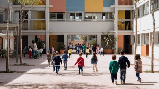 Fachada de un colegio con niños y niñas accediendo al patio y a las aulas.