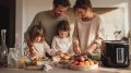 Familia preparando la cena con una freidora de aire en una cocina luminosa.