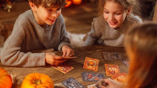 Un grupo de niño jugando a un juego de mesa inspirado en Halloween